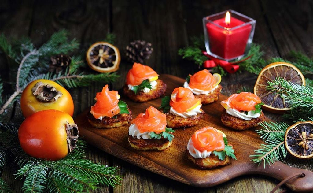 Aperitivo de salmón ahumado sobre tortitas de patata y caqui