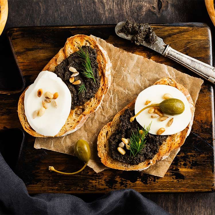 Tostas con 'tapenade' de piñones y mozzarella