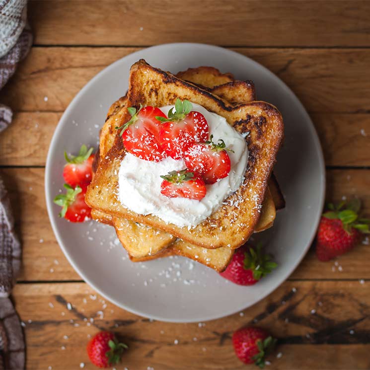 Tostadas con mantequilla, miel, queso fresco, fresas y coco rallado