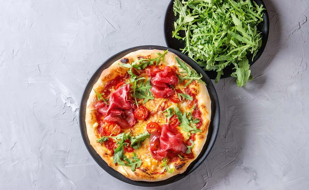 Pizza casera con bresaola, tomatitos y rúcula