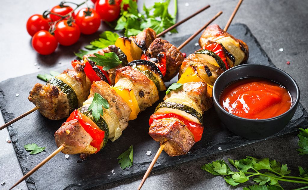 Brochetas de cerdo y verduras con salsa de tomate cherry