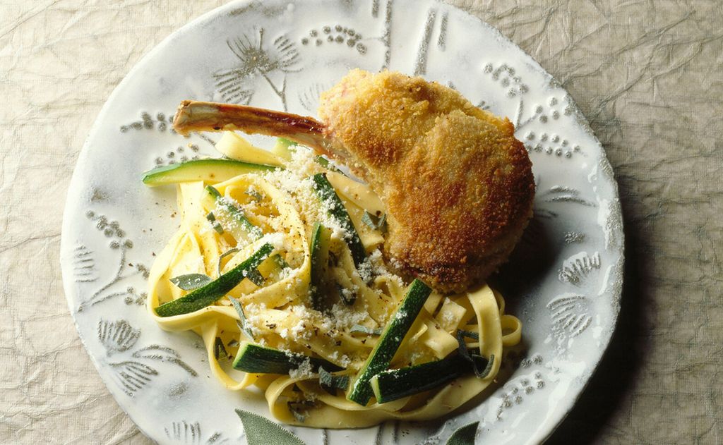 Chuletas de cordero empanadas con pasta y calabacín