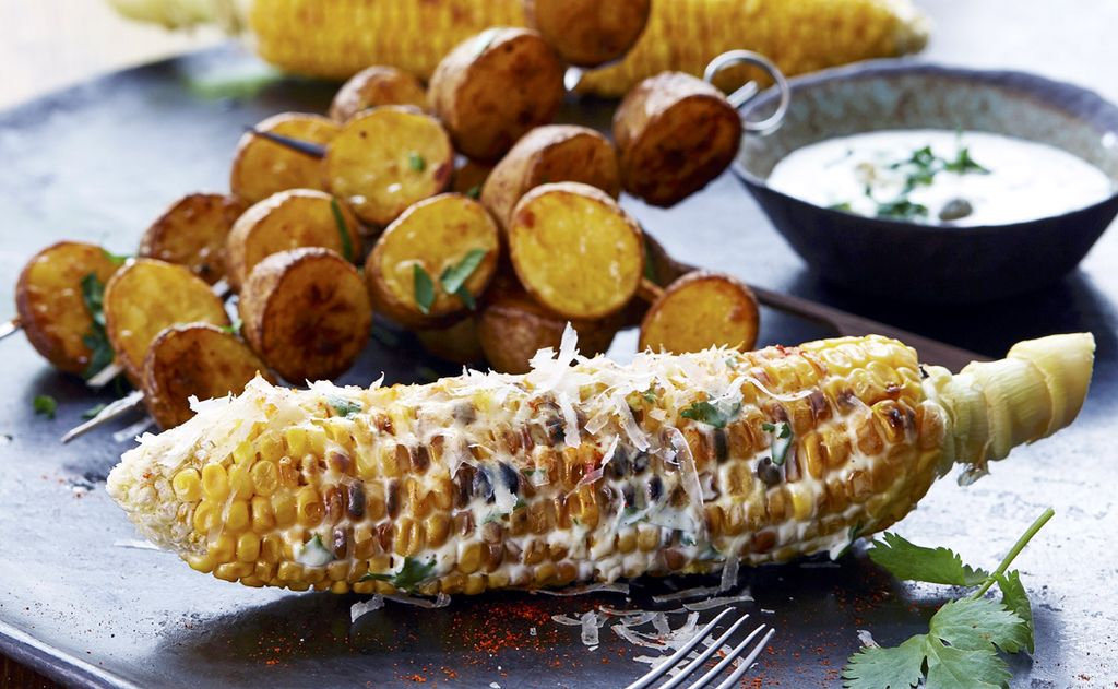 Mazorcas y brochetas de patata a la parrilla con salsa tres quesos