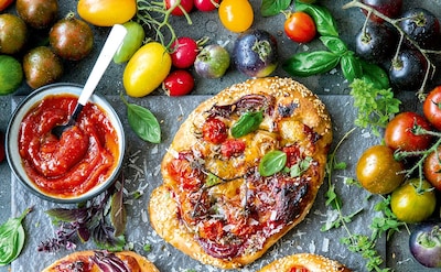 'Pizzetas' de tomates variados con cebolla morada y queso parmesano