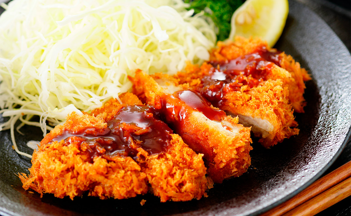 'Tonkatsu' troceado con salsa y ensalada de col