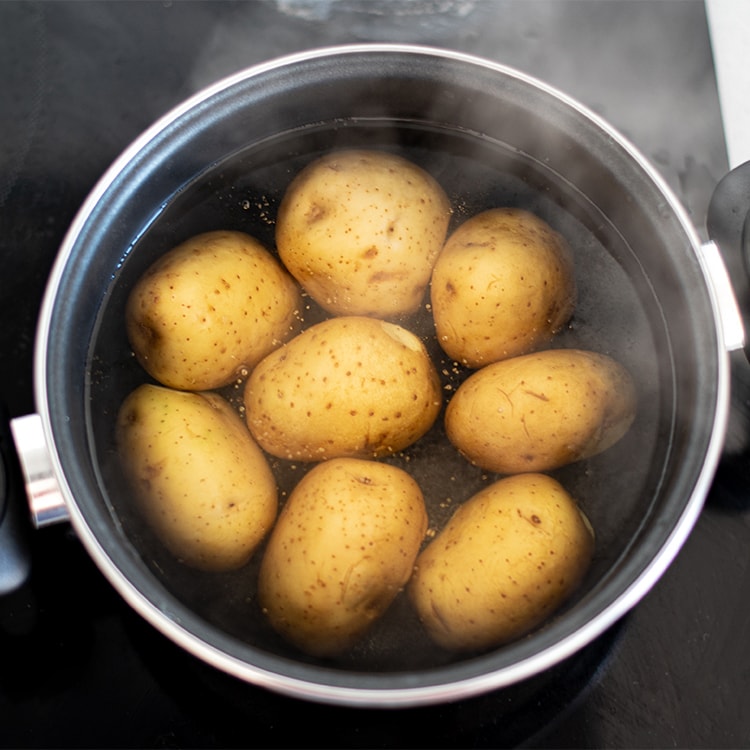 Patatas enteras con piel hirviendo