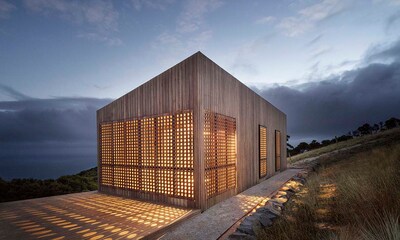 Una casa de madera bajo las estrellas concebida como una caja de luz