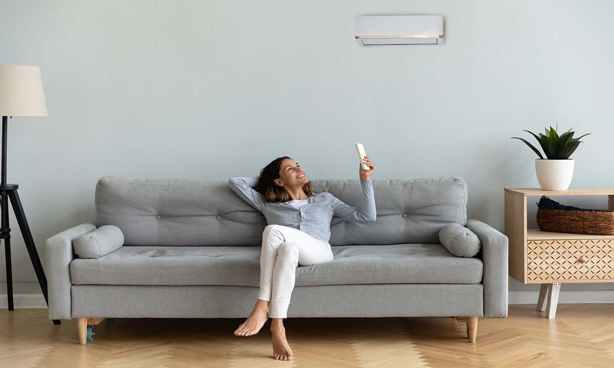 Mujer disfrutando del aire acondicionado en el salón de su casa