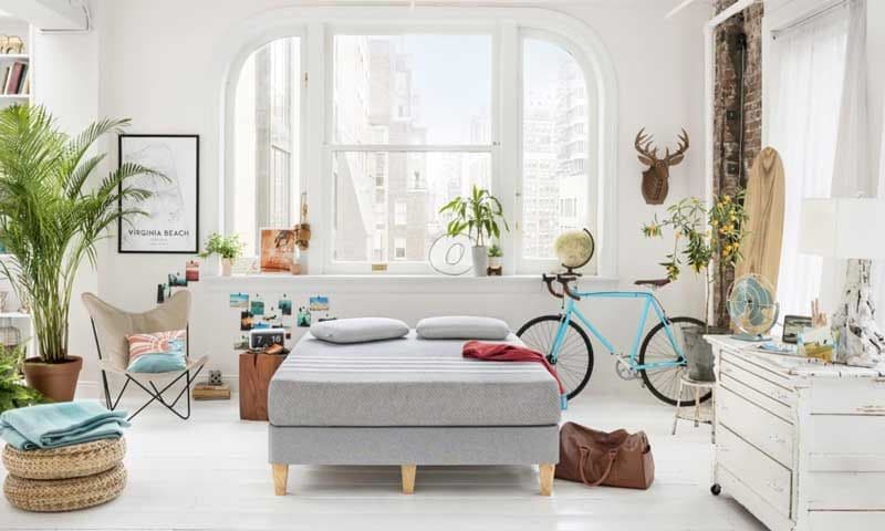 Dormitorio de matrimonio tipo loft en color blanco, con bicicleta vintage azul