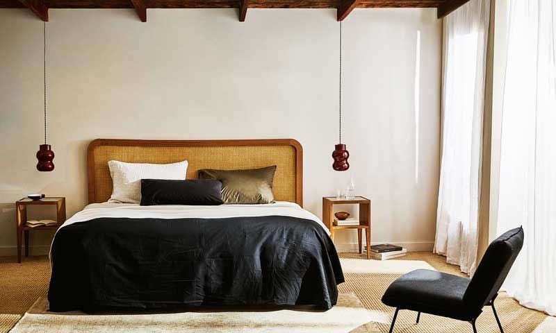 Dormitori de matrimoni amb llit amb capçal de reixeta i funda nòrdica de color negre
