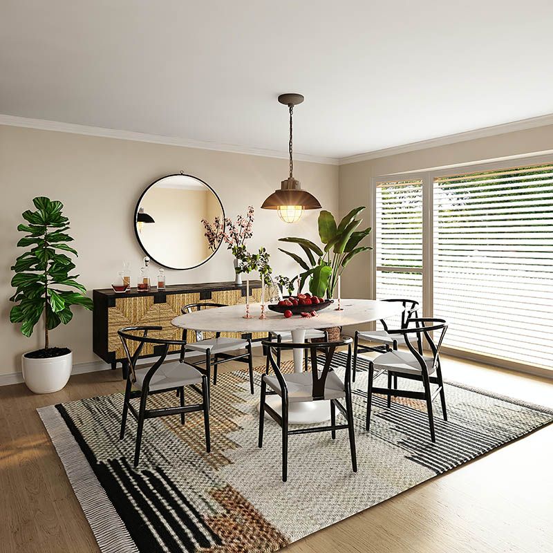 Comedor con las pinturas pintadas de color beige con una mesa redonda con patas negras y sobre de mármol. 