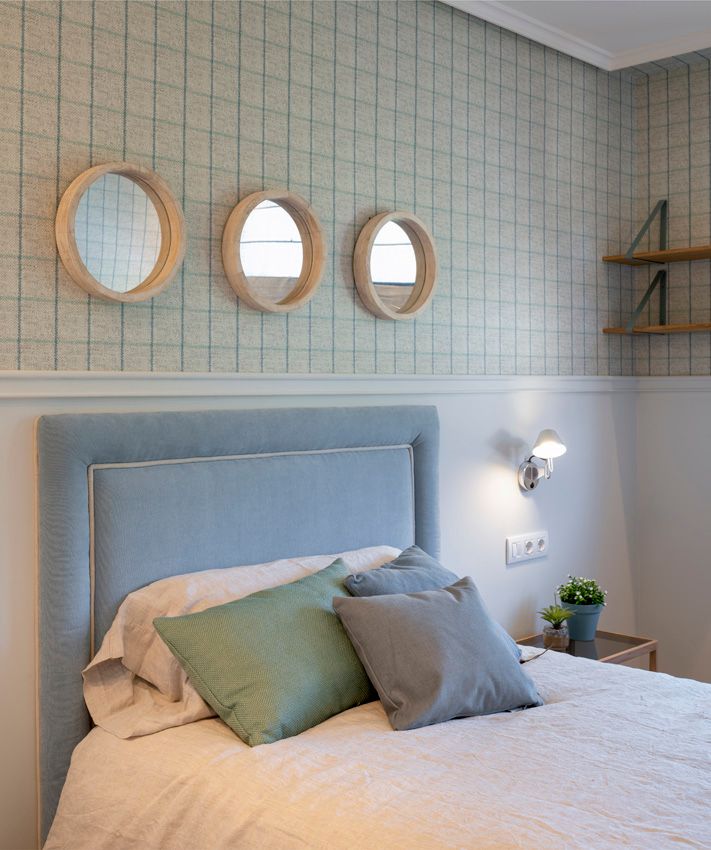 Tres espejos sobre la cama, redondos para ofrecer una estética marinera