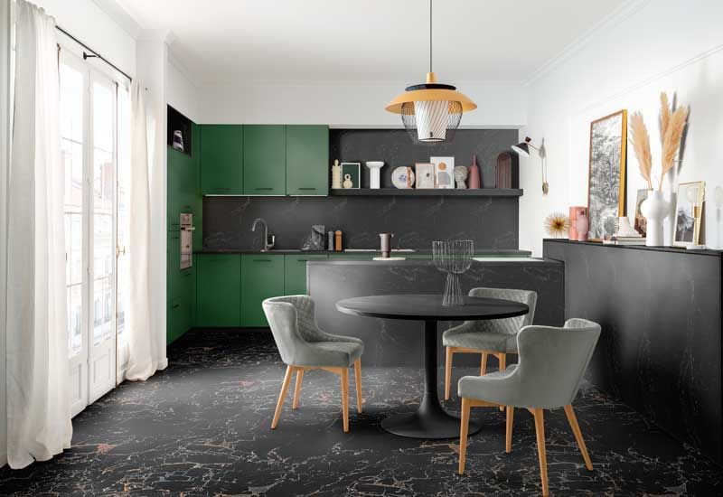 Cocina con suelo negro, 'office' con mesa redonda y muebles de color verde