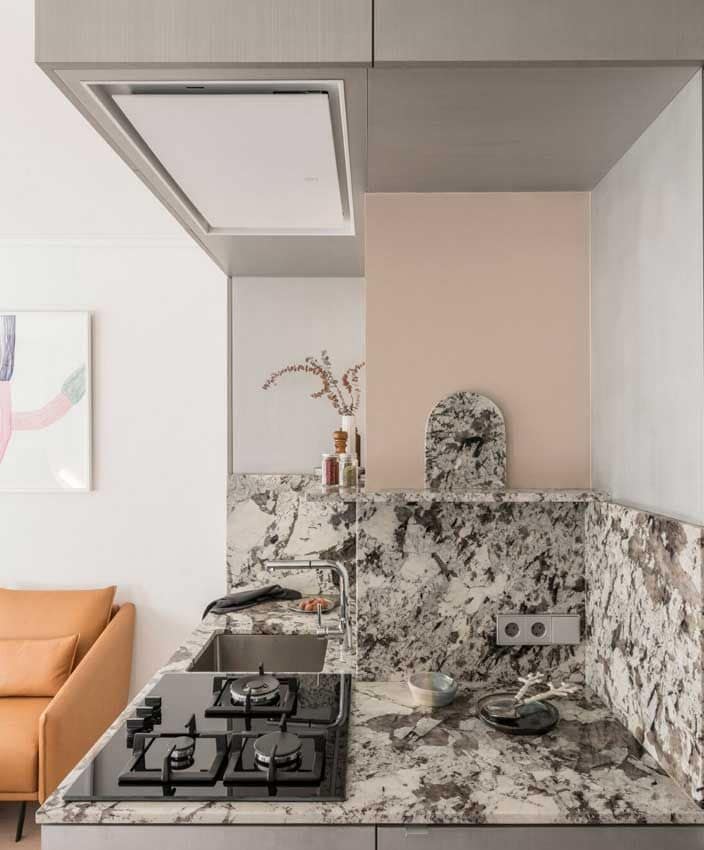 Mini cocina con salpicadero en piedra y rematado con estante