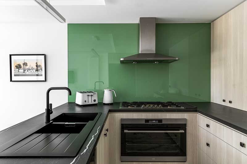 Cocina con pared con cristal verde