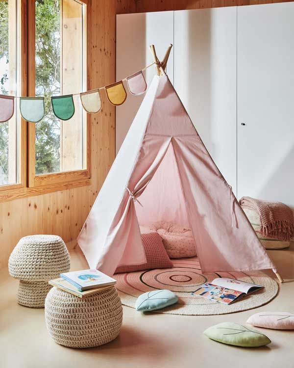Tipi de color rosa con alfombra y puf