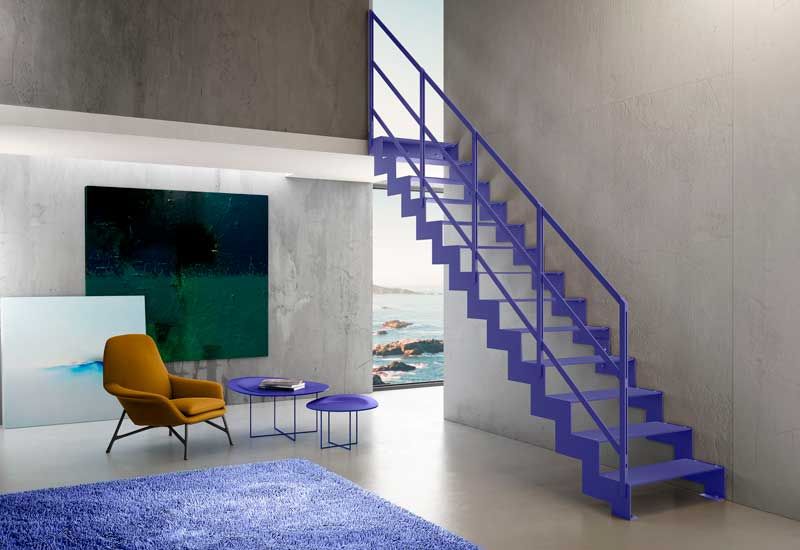 Salón con vistas al mar con escalera, alfombra y mesas auxiliares de color morado