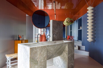 Espacio de Axor con unos lavamanos en piedra de Sensa escultóricos, al igual que el radiador y el espejo. Se trata de una propuesta de Estudio Reciente