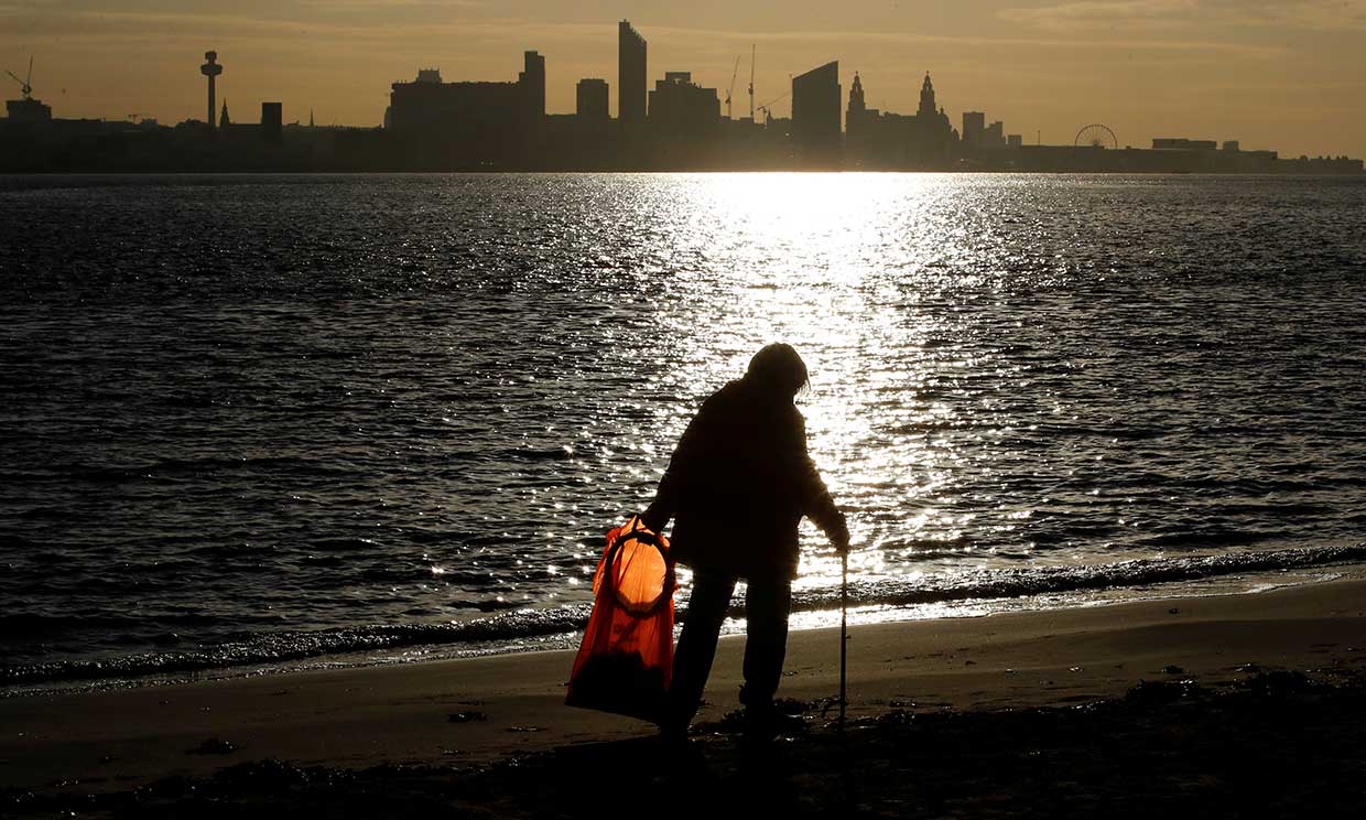 Mujer limpiando basura de la playa