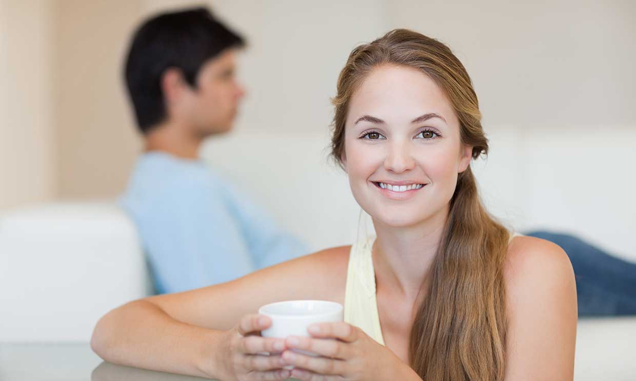 mujer tomando cafe frente a un hombre
