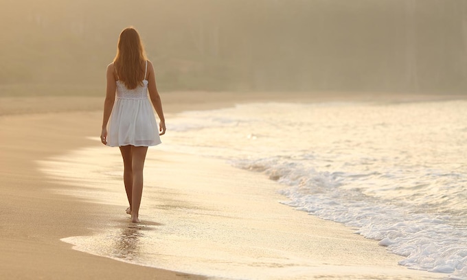 mujer paseando por la playa