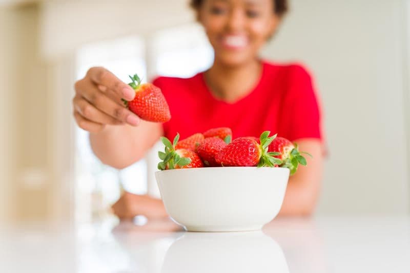 mujer tomando fresas