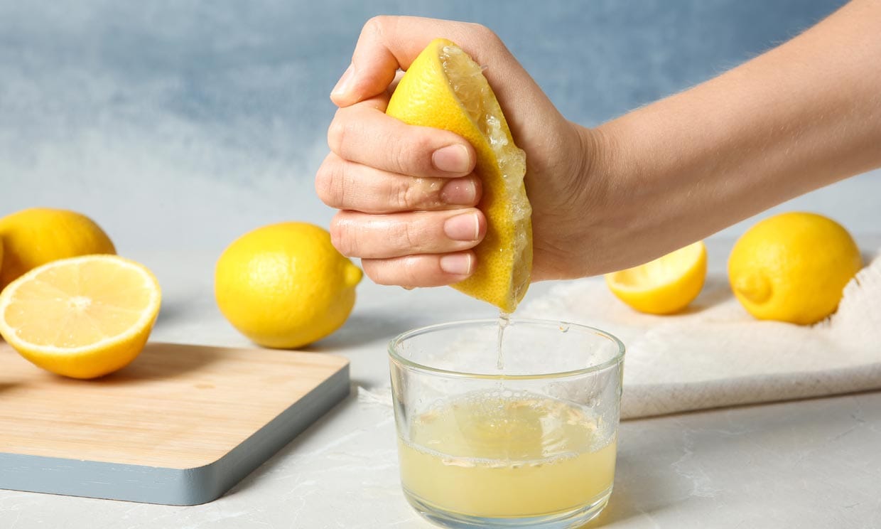 mujer exprimiendo un limón con las manos
