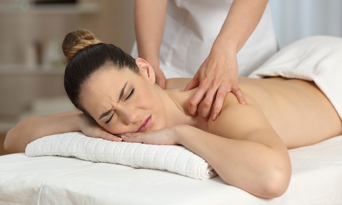 Mujer recibiendo un masaje por sufrir dolores musculares
