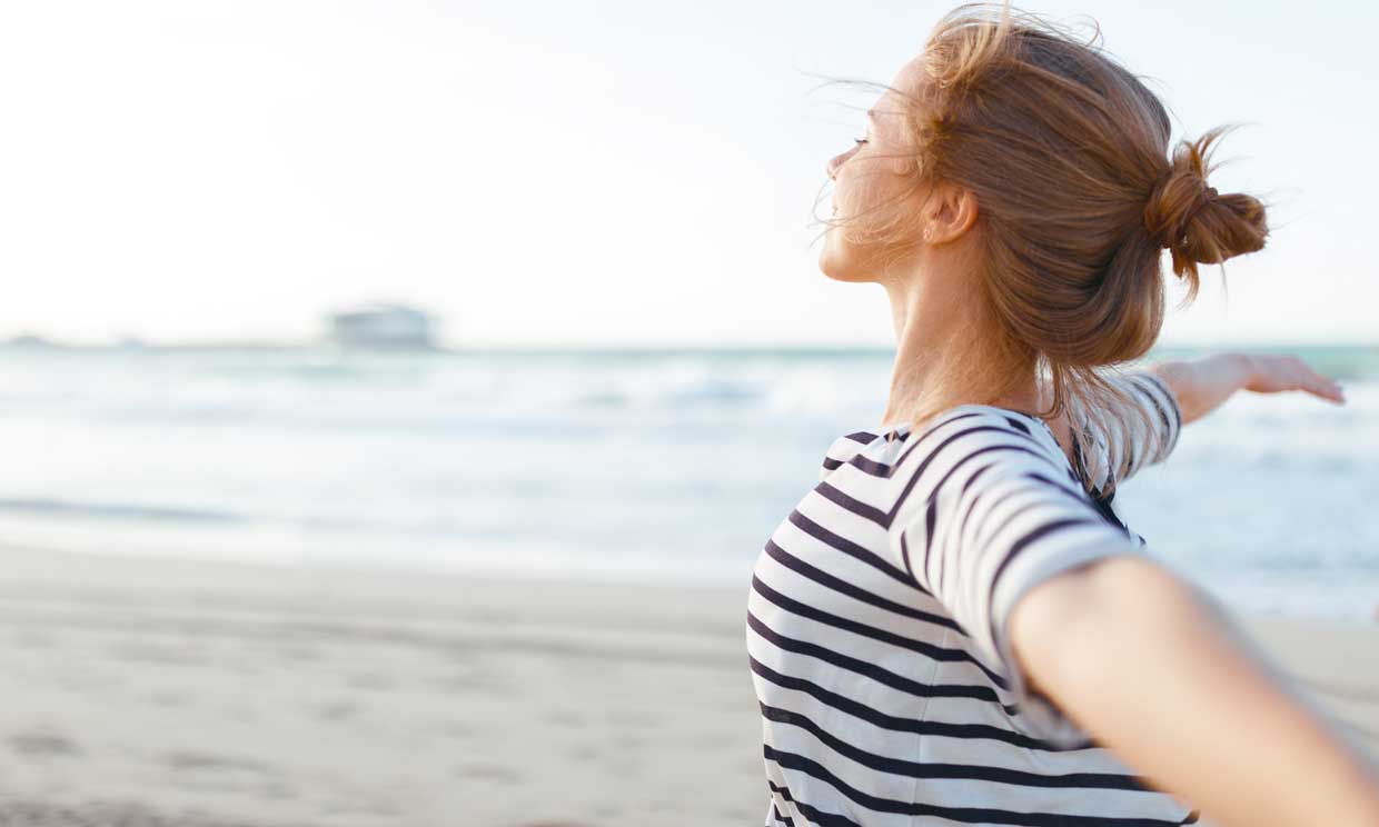 mujer respirando en la playa