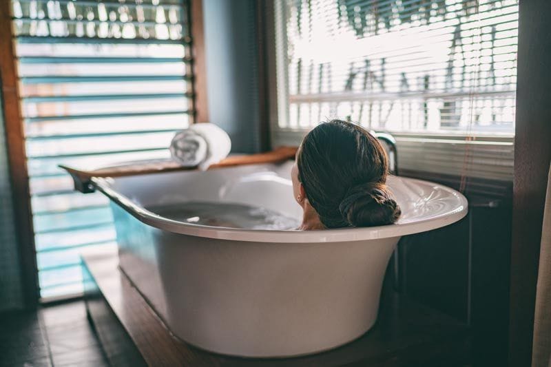 mujer dándose un baño relajante