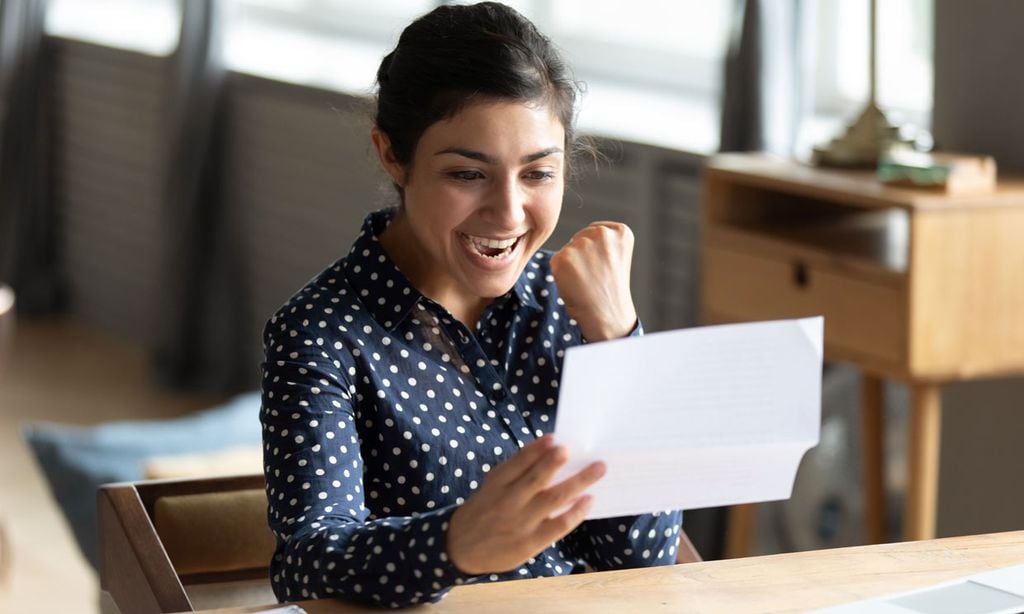 mujer feliz mirando un documento