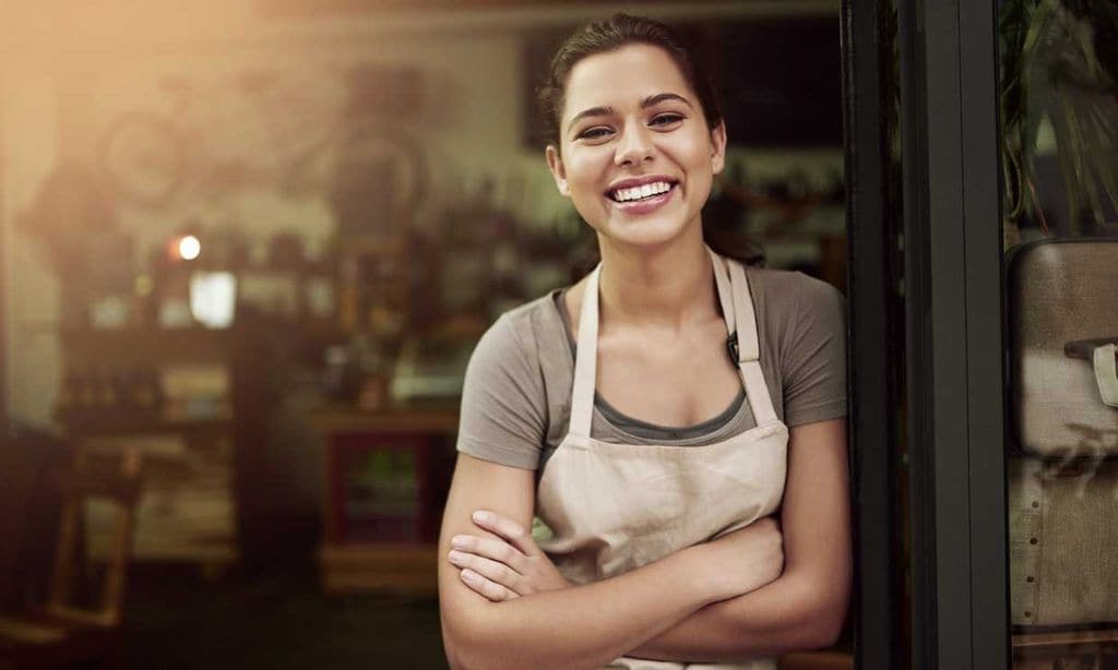 Mujer segura de sí misma a la puerta de una tienda de café