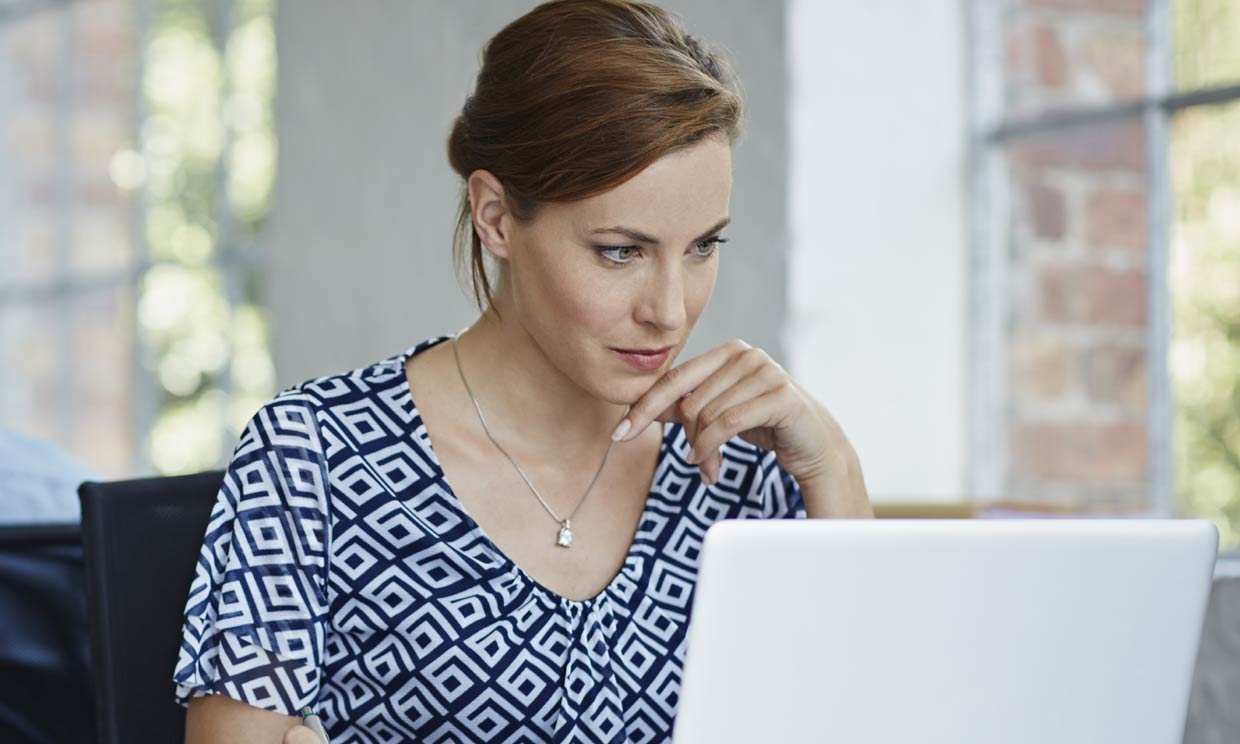 Mujer delante de un ordenador muy concentrada
