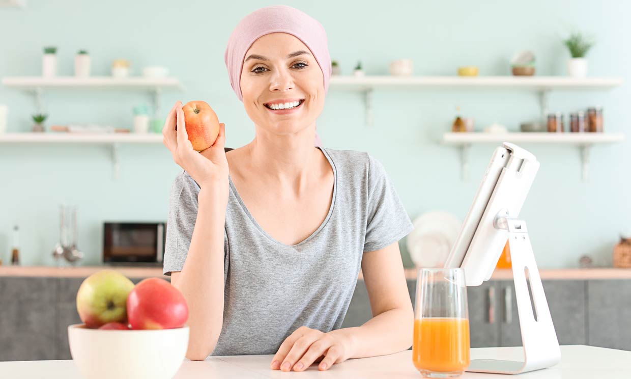 mujer con tratamiento de quimioterapia con una manzana