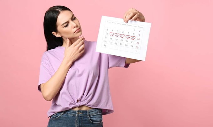 mujer con un calendario en el que marca su menstruación