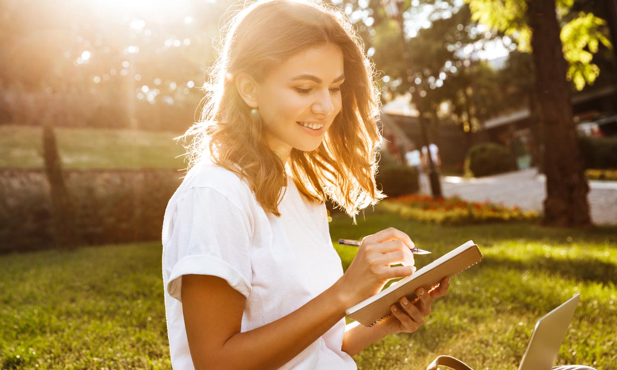 Mujer escribiendo al aire libre