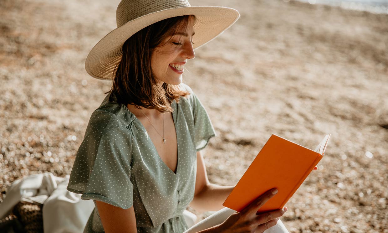 Chica con una libreta en la playa