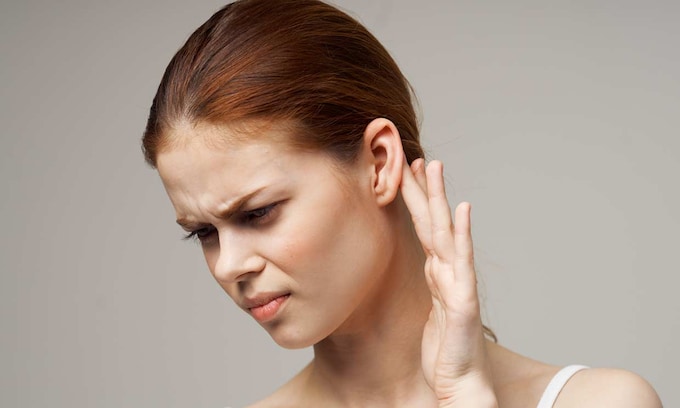 mujer con dolor en la oreja