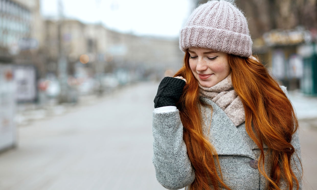 mujer mirando su pelo en invierno