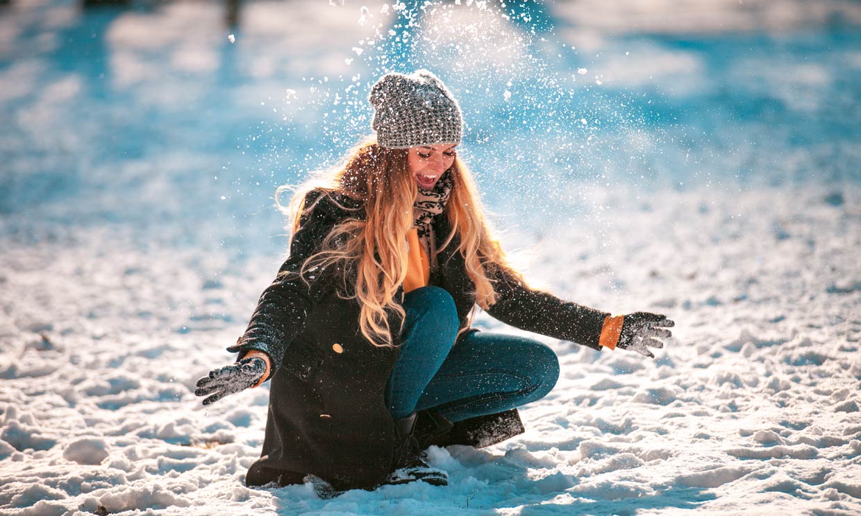 Chica feliz jugando con la nieve