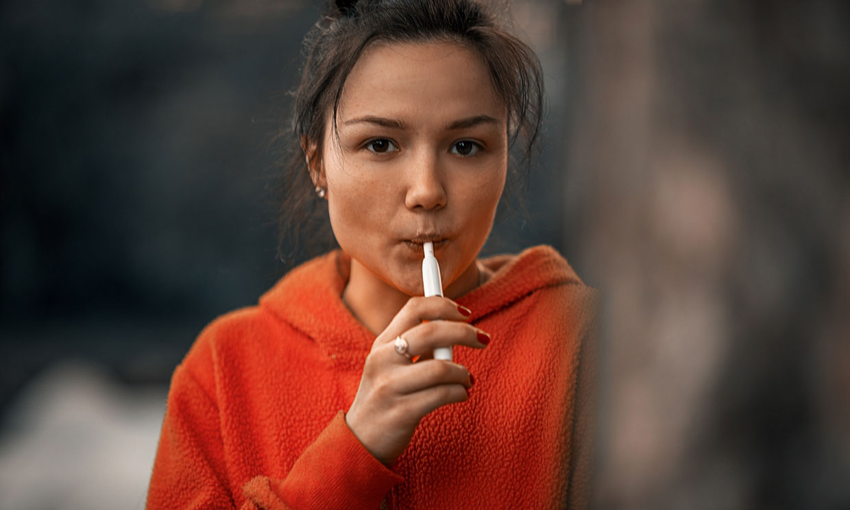 Chica con cigarro electrónico