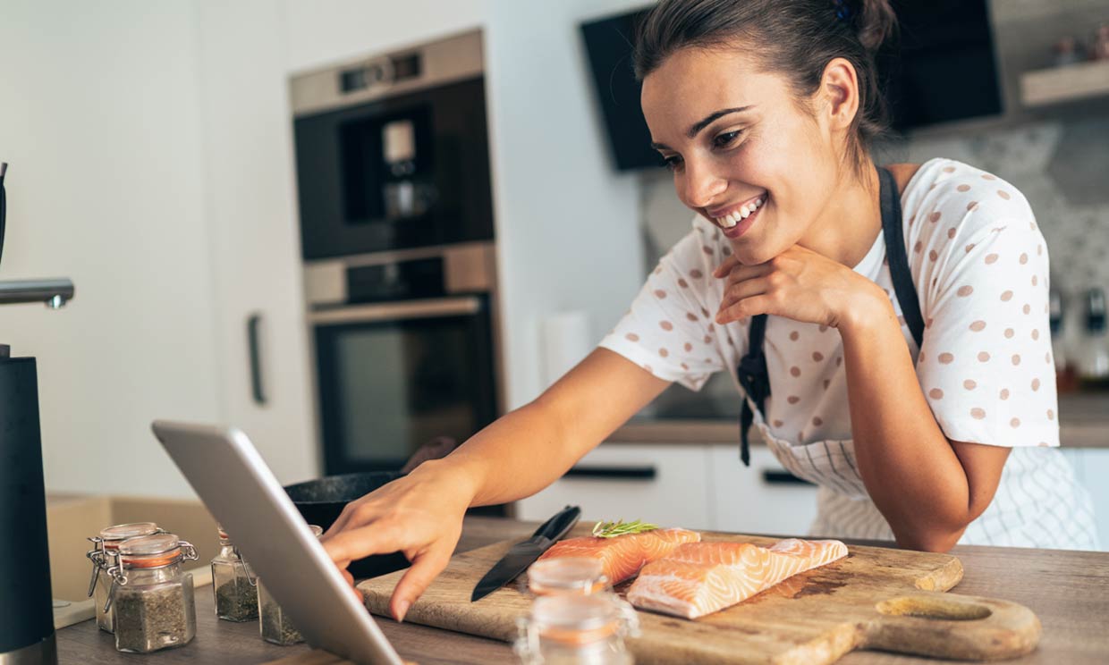 Chica cocinando salmón