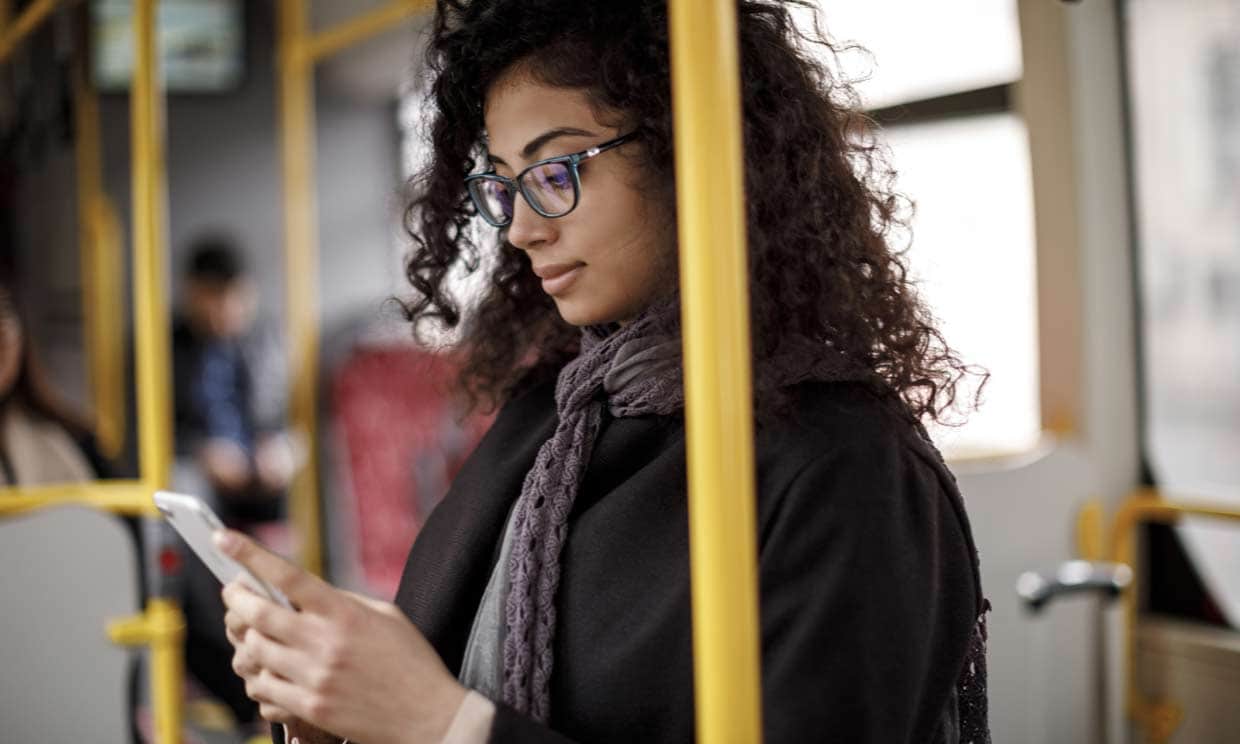 mujer mirando el móvil en el autobús