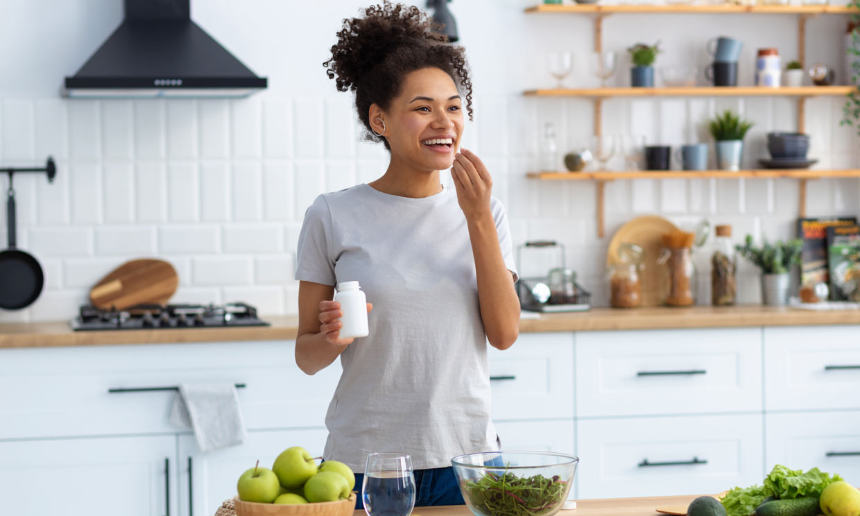 mujer tomando suplementos nutricionales