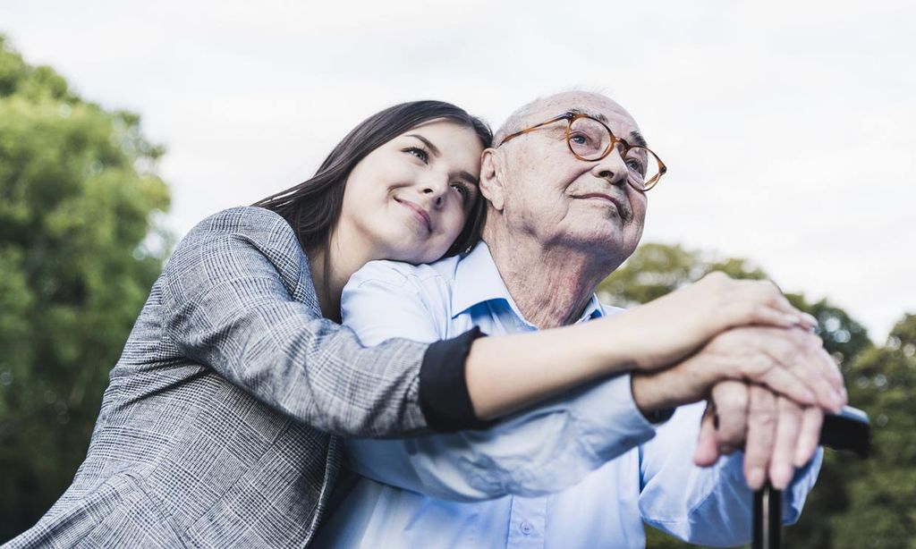 anciano y su familia abrazados