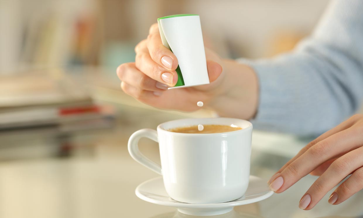 mujer echando sacarina al café