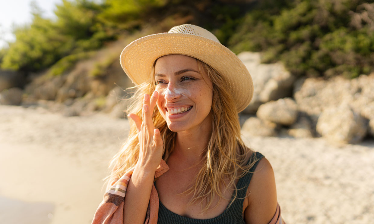 mujer aplicándose crema solar