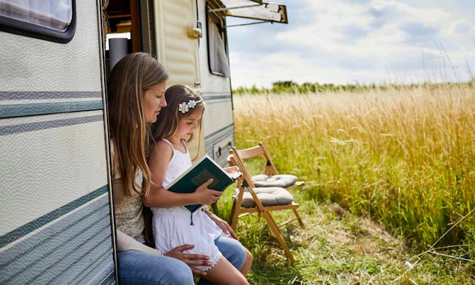 madre e hija leyendo en una caravana