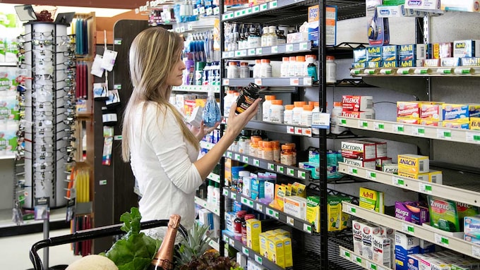 Mujer comprando en el supermercado vitaminas