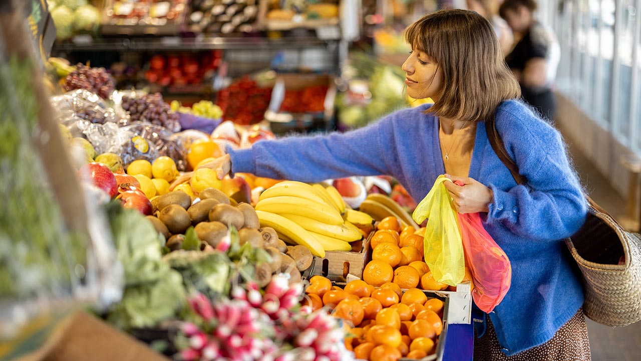 mujer comprando fruta en el supermercado